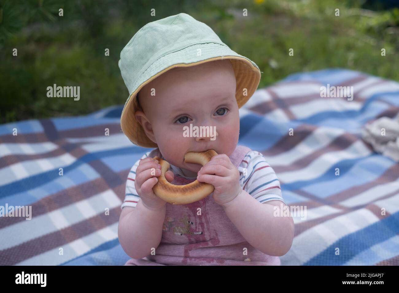 Ritratto di bambino carino con il pane nelle sue mani che mangia durante il picnic all'aperto Foto Stock