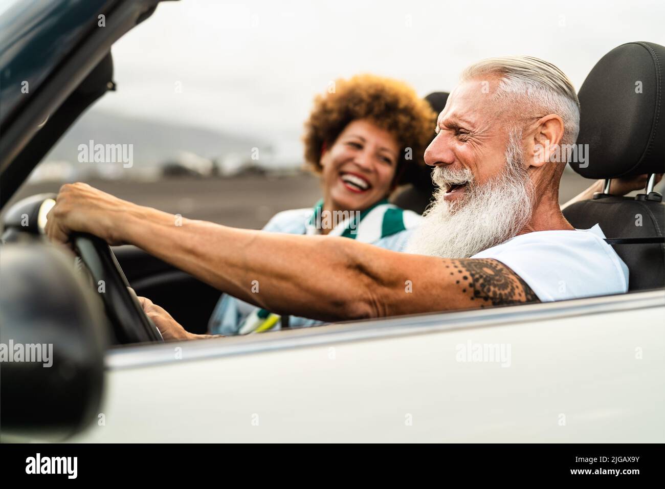 Coppia anziana felice divertirsi guidando su una nuova auto convertibile - concetto di stile di vita della gente di viaggio Foto Stock