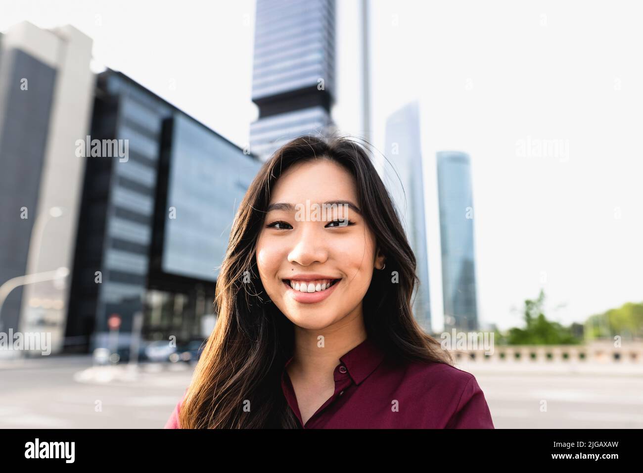 Felice donna d'affari asiatica fuori ufficio aziendale Foto Stock