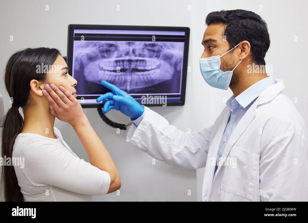 Il vostro dente di saggezza realmente sta sviluppandosi nella vostra mascella ossea. Un dentista che discute i risultati di un paziente i denti x ray. Foto Stock