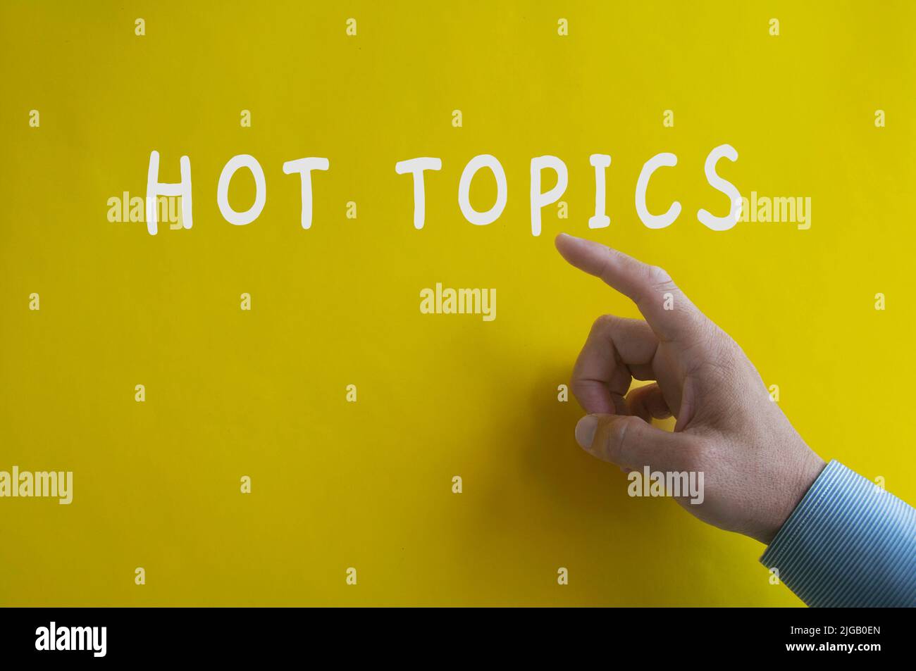 Mano che punta il testo Hot Topics sullo sfondo giallo della copertina. Informazioni sugli argomenti principali Foto Stock