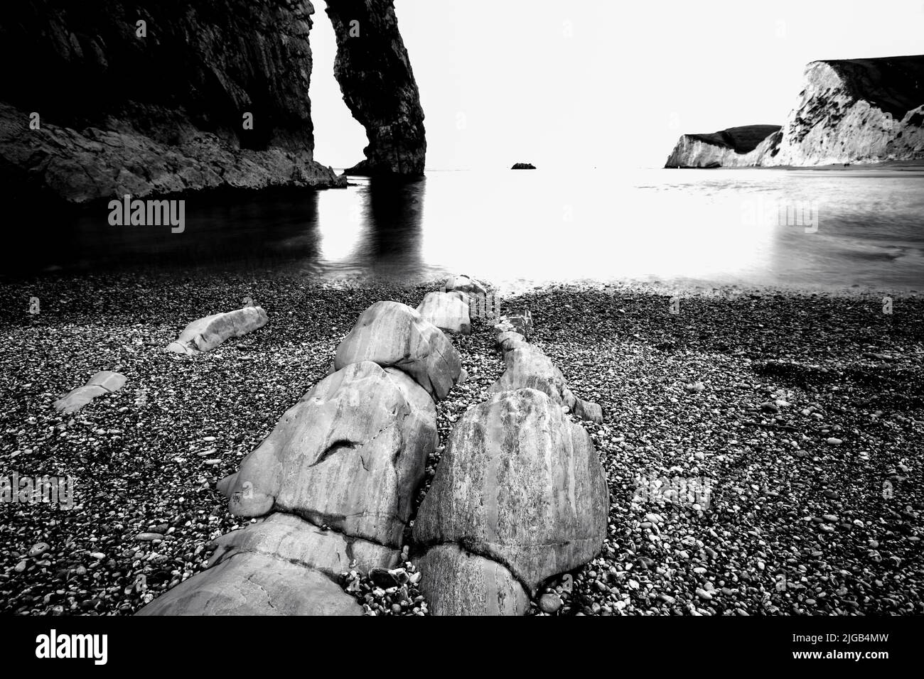 Una riva del mare e una roccia in bianco e nero Foto Stock