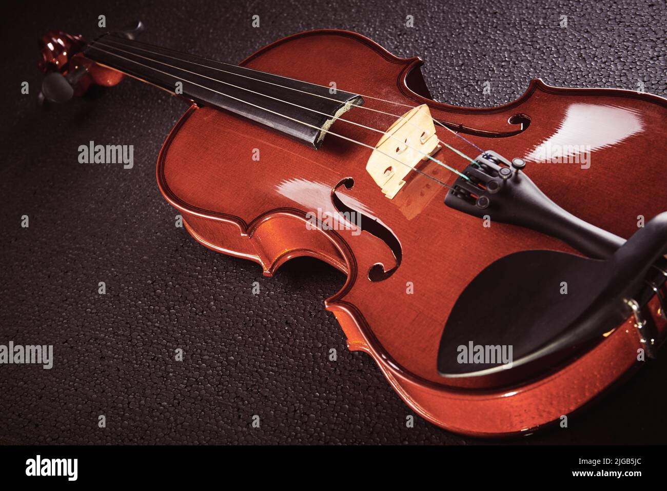 parte di un violino su sfondo nero con luce dura Foto Stock