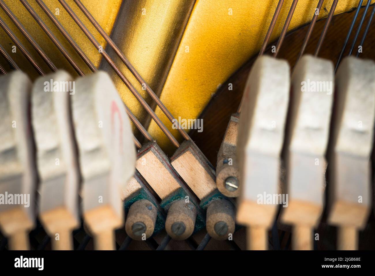 Smorzatori di un pianoforte verticale incorniciato da martelli Foto Stock