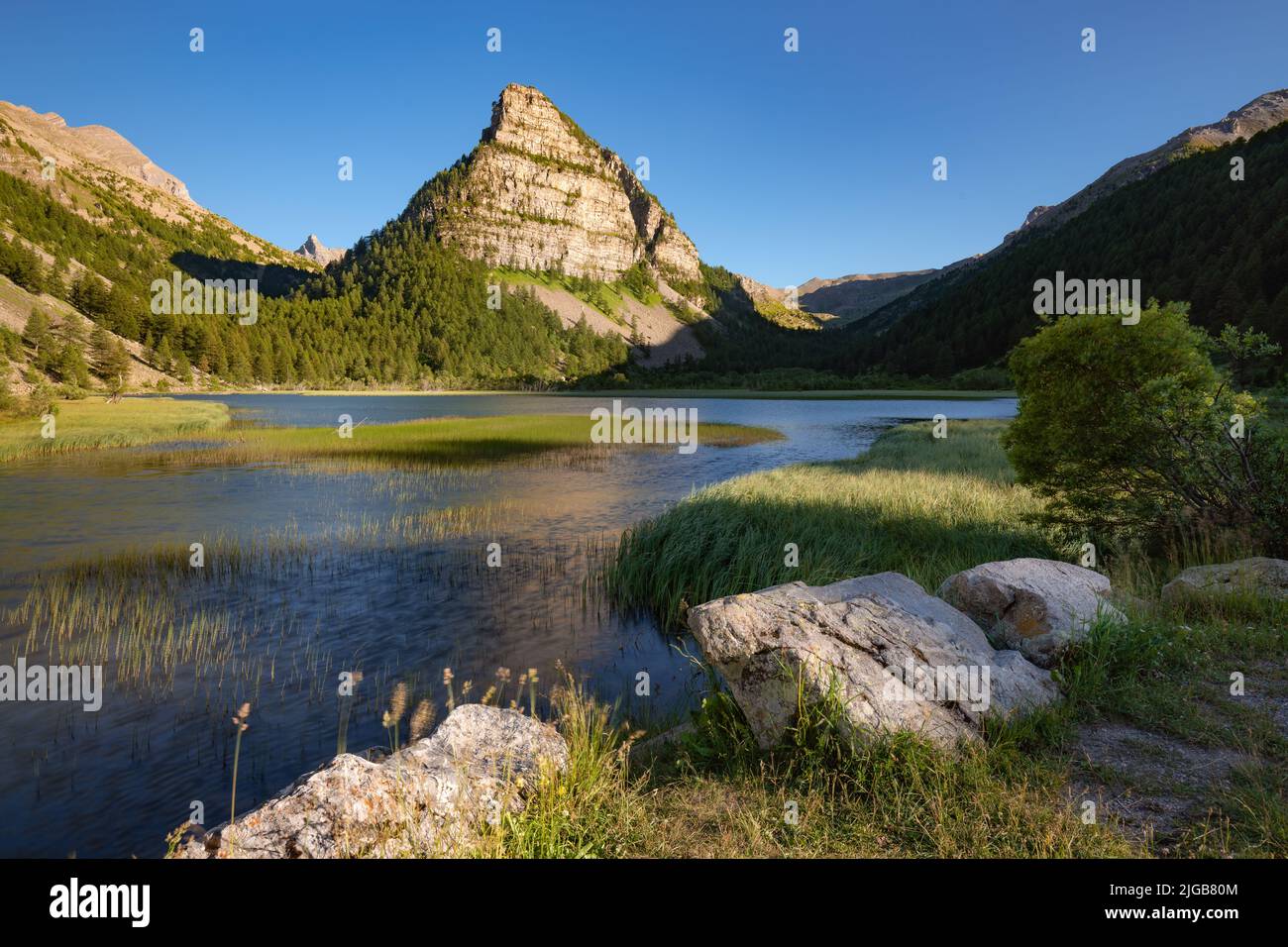 Lac des Sagnes in estate con la Tour des Sagnes montagna nel Parco Nazionale del Mercantour al tramonto. Jausiers, Valle dell'Ubaye, Alpi dell'alta Provenza, Alpi Foto Stock