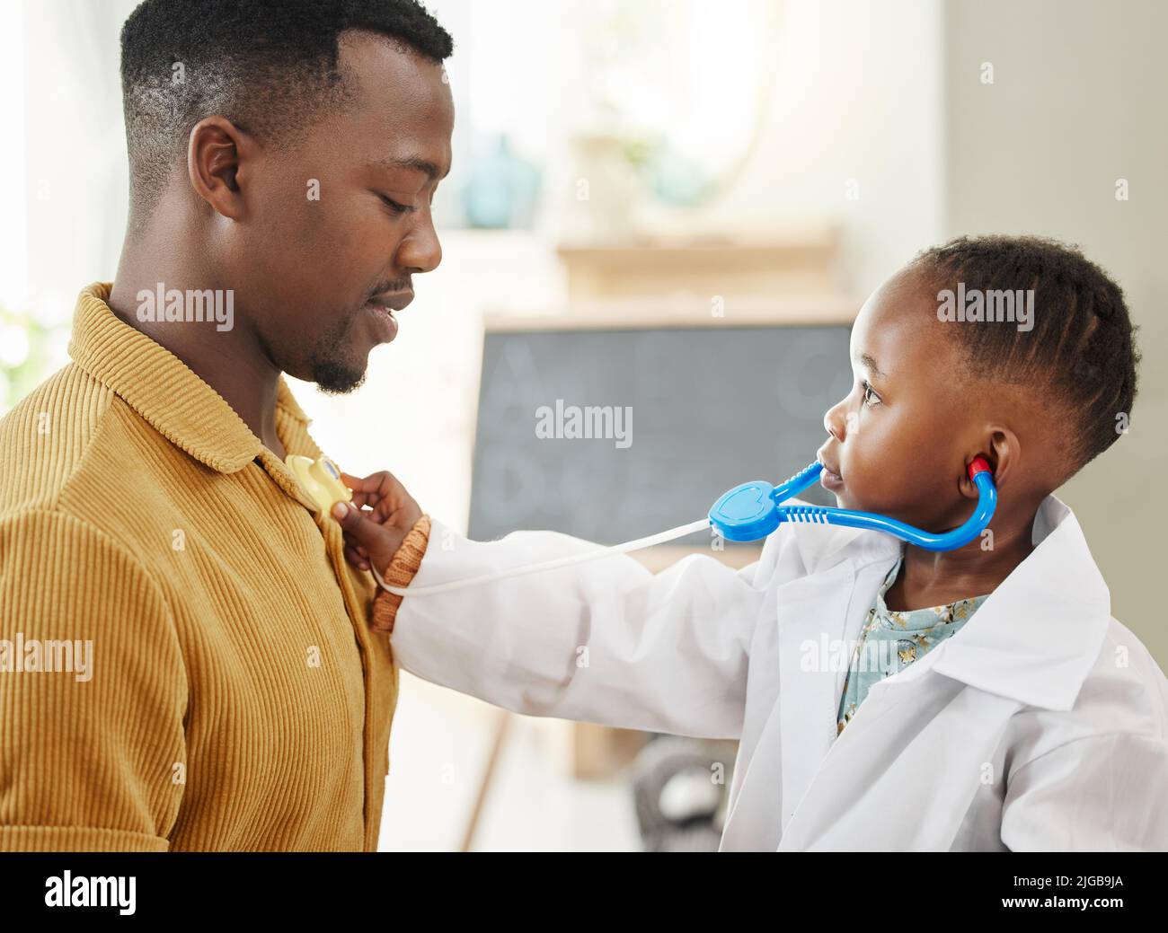 Il tuo petto mi sembra bloccato. Una bambina che finge di essere un medico mentre gioca con suo padre. Foto Stock