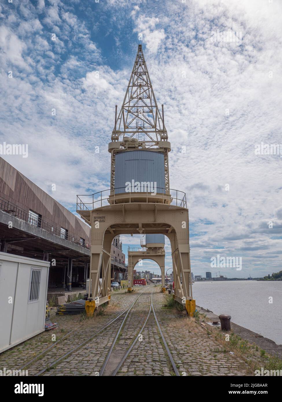 Anversa, Belgio, 02 luglio 2022, vecchia gru sulla banchina accanto al fiume Scheldt sulle rotaie vicino agli hangar Foto Stock