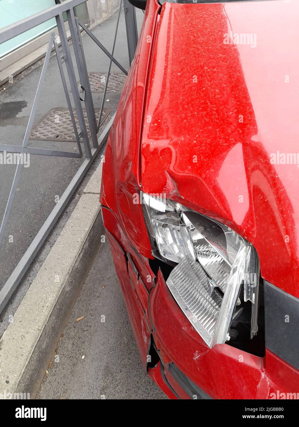 Un faro rotto di un'auto rossa in un negozio Foto Stock