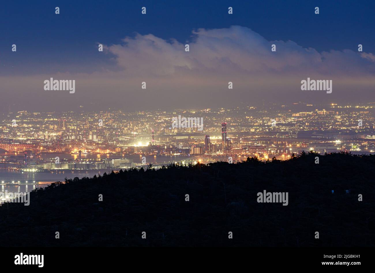 Cielo blu e nuvole sulle luci della città di notte Foto Stock