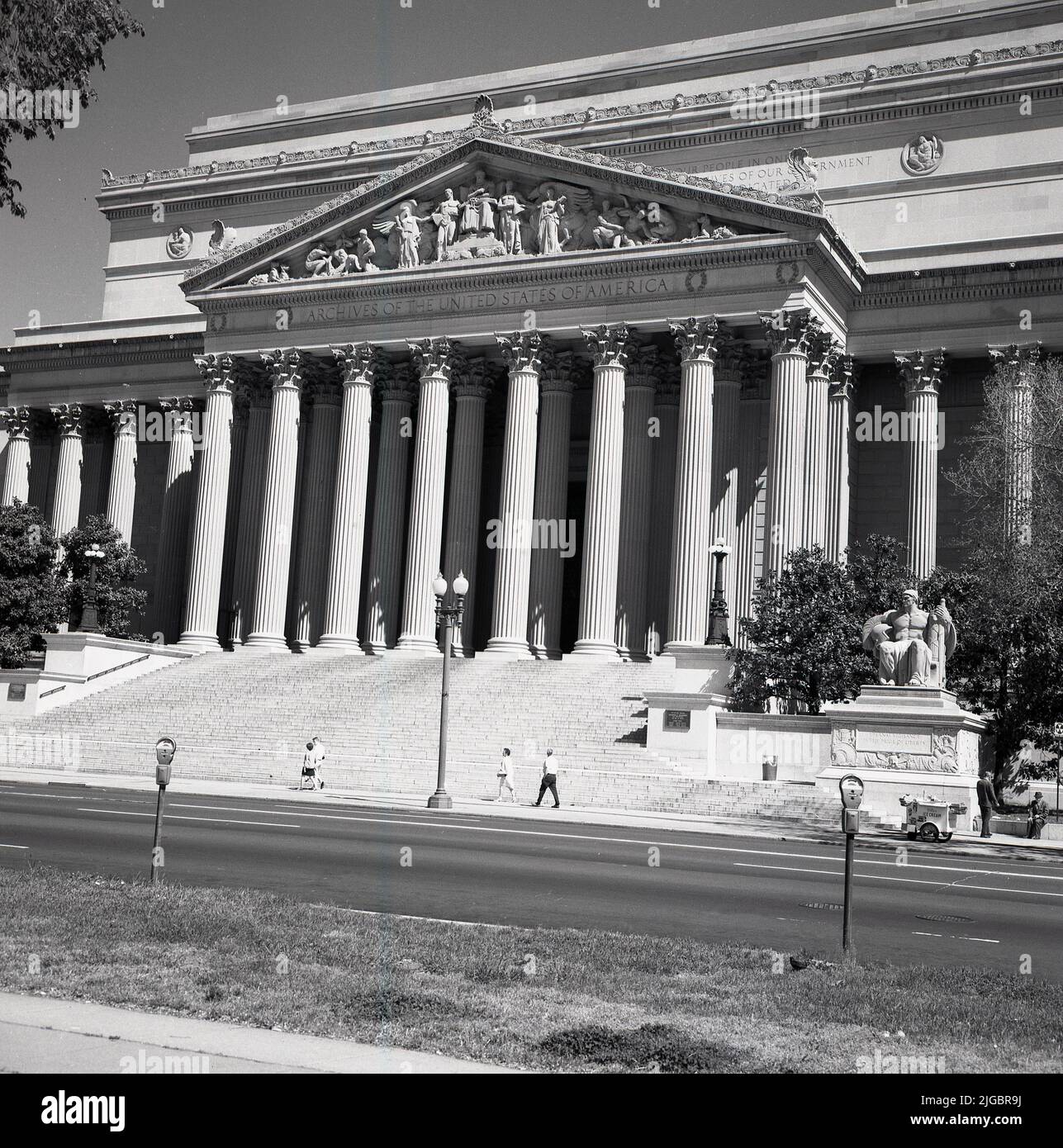 1960s, vista storica da questa era dell'esterno del grande edificio colonnato, l'Archivio Nazionale degli Stati Uniti d'America, Washington, DC, USA. Progettato in stile neoclassico da John Russell Pope, con le sue peculiari colonne alte 53 piedi, il museo ospita la Costituzione, la legge dei diritti e la Dichiarazione di Indipendenza. Carretto gelato Star sul marciapiede. Foto Stock