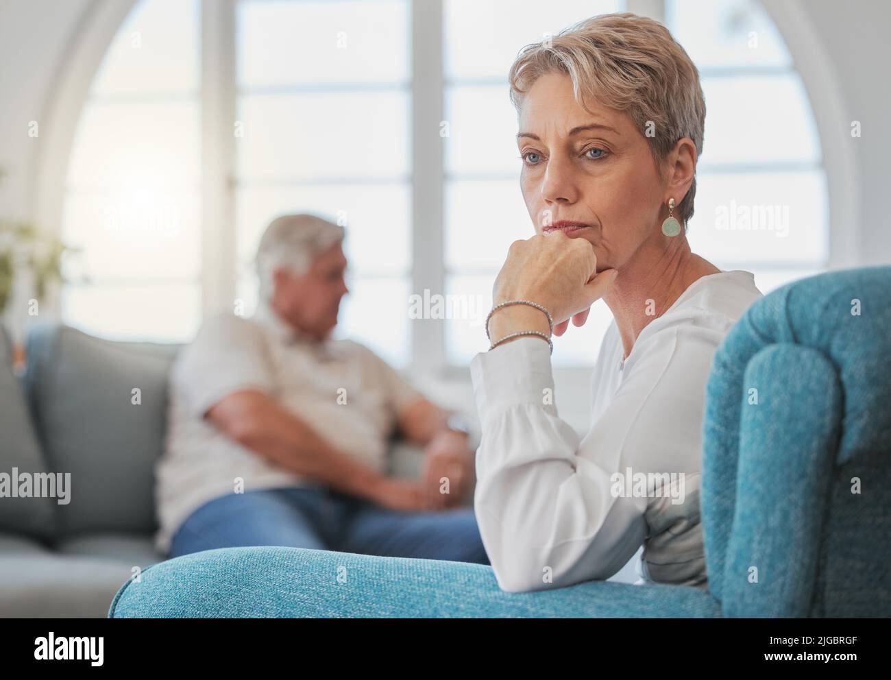 Ne è valsa la pena: Una coppia anziana, dopo un'argomentazione, ha un aspetto triste e sconvolto mentre si siede nel soggiorno. Foto Stock