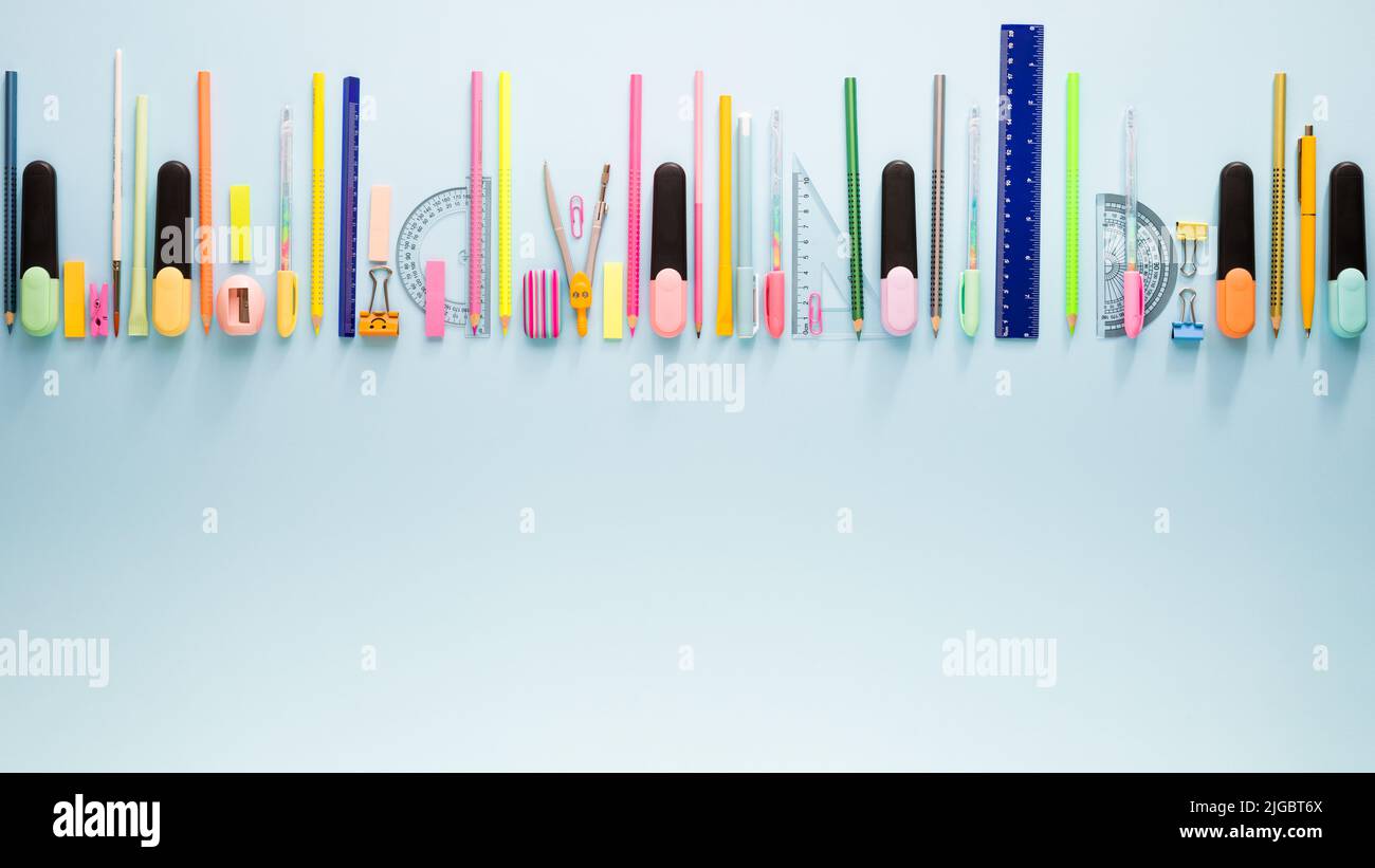 Cancelleria scolastica su sfondo blu. Modello fotografico creativo di ritorno a scuola con spazio di copia Foto Stock