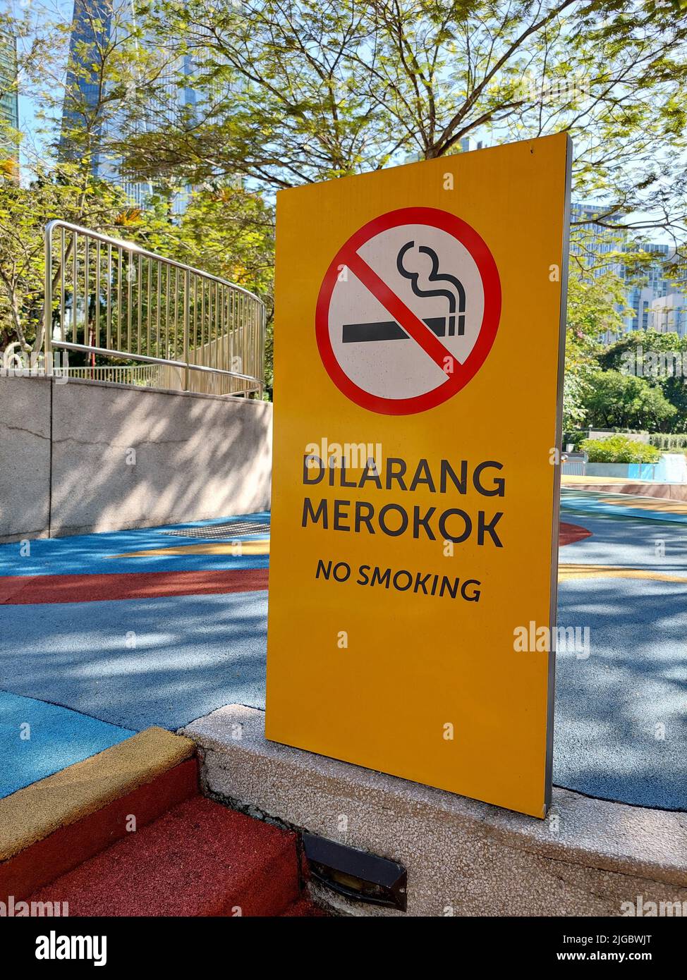 Una foto verticale di un cartello per non fumatori in un parco pubblico Foto Stock