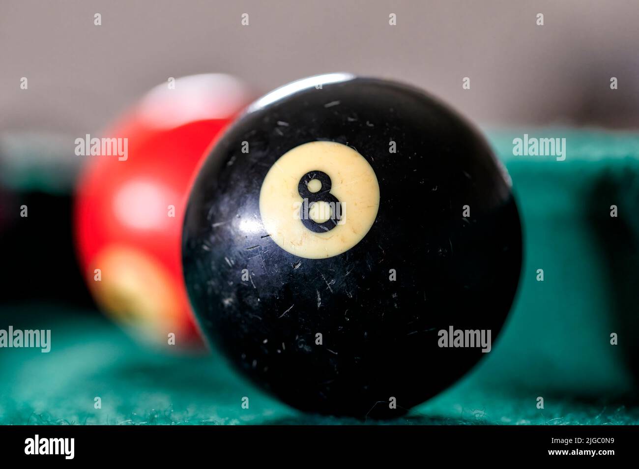 Palla da biliardo nera con il numero 8 su un tavolo da biliardo verde con altre palle nelle vicinanze. Foto Stock