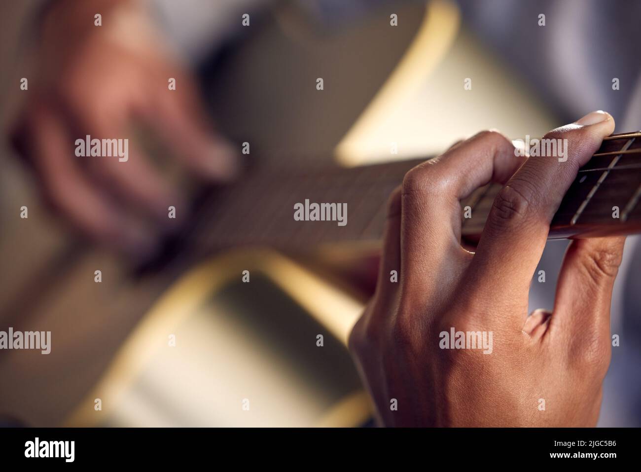 Imparare un nuovo accordo. Primo piano di un uomo irriconoscibile che suona una chitarra acustica. Foto Stock