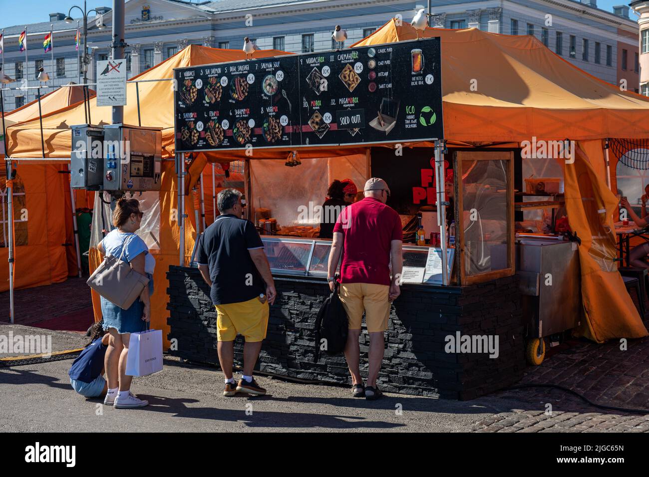 Clienti allo stalla di cibo di mare nella piazza del mercato, Helsinki, Finlandia Foto Stock