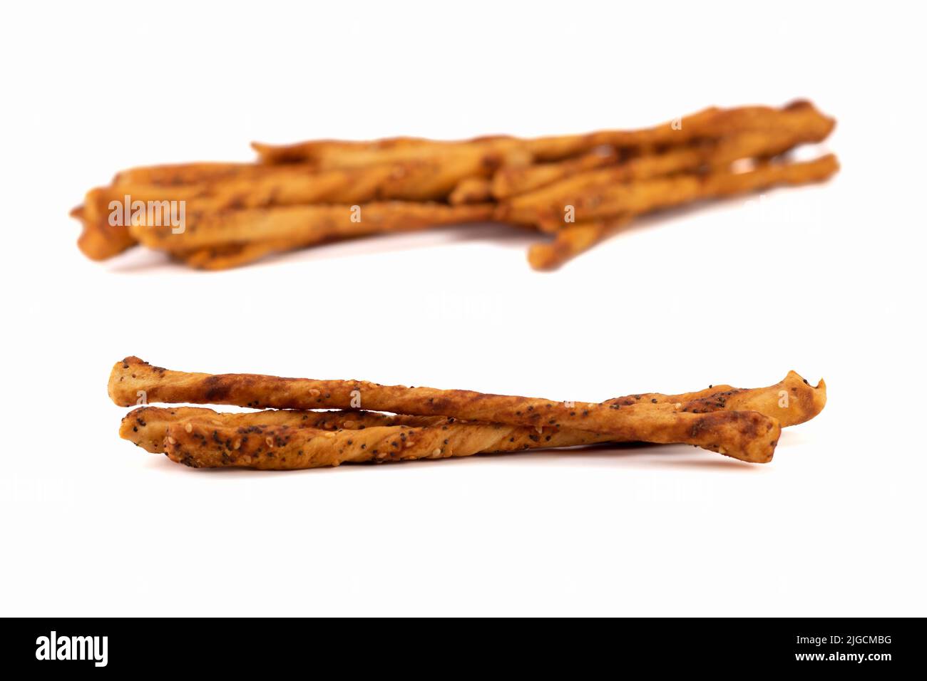 Bastoncini salati al forno con semi di sesamo e papavero isolati su sfondo luminoso. Messa a fuoco selettiva. Foto Stock