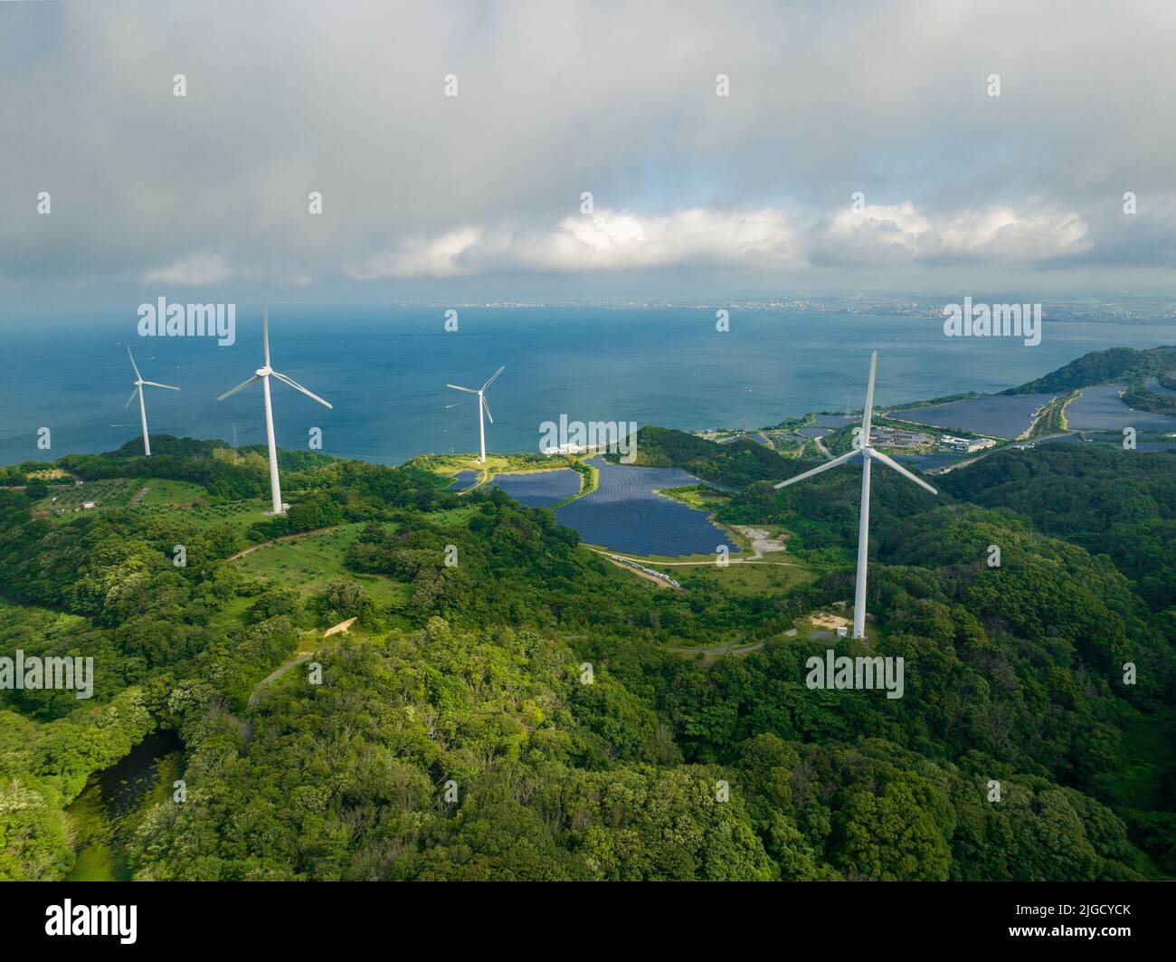 Turbine eoliche e pannelli solari con patch di sole attraverso la nuvola Foto Stock