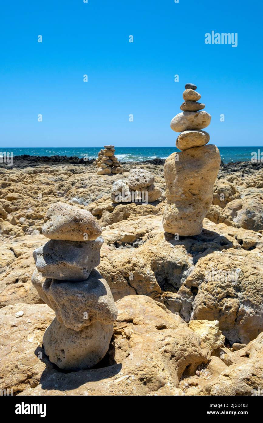 Rocce Mariolas, equilibrio verticale con rocce da spiaggia, zen e vista sulla salute mentale vicino all'oceano. Libera le viste spirituali, la consapevolezza e naturale. Foto Stock