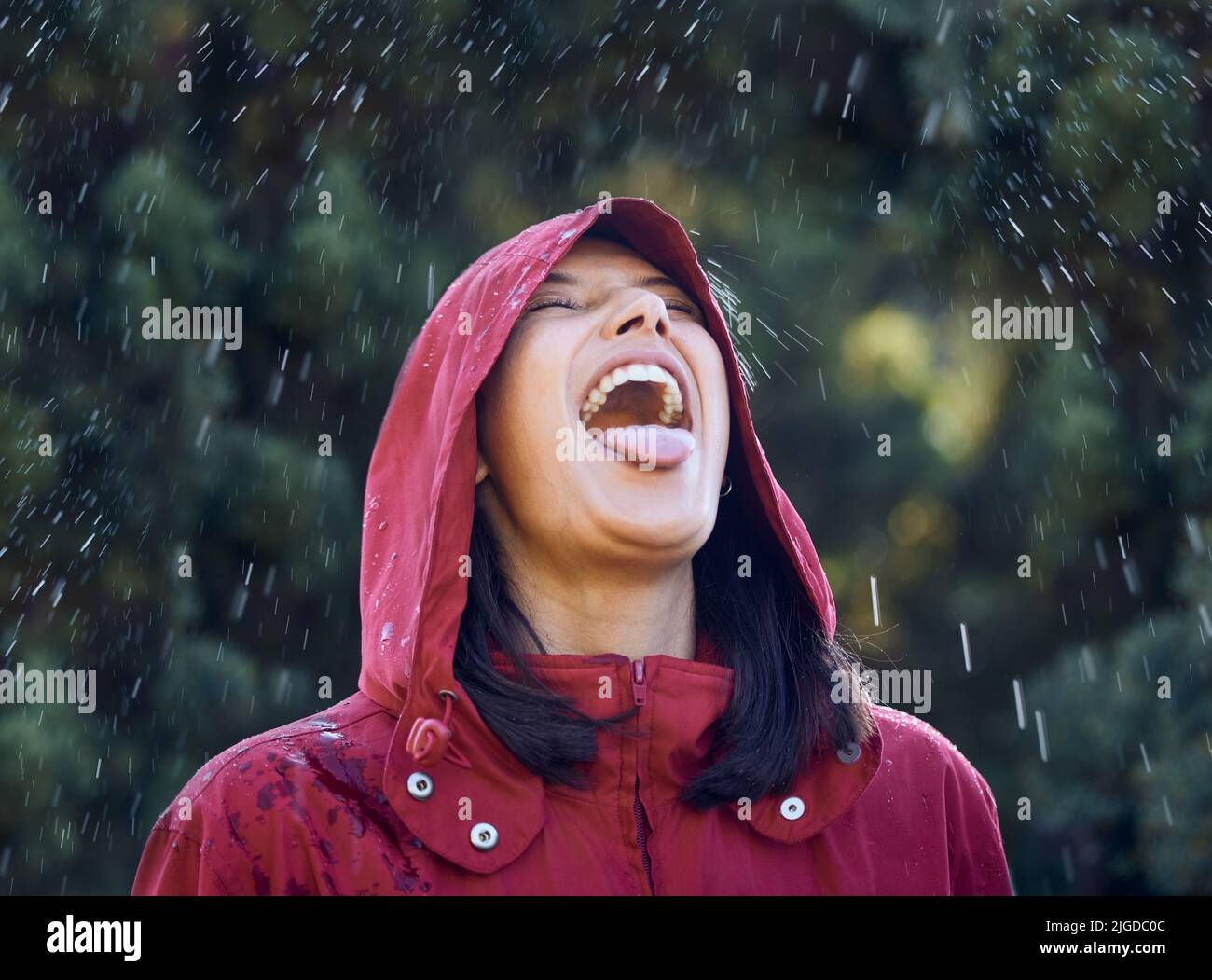 Senza pioggia, non ci saranno arcobaleni, una giovane donna che attacca la sua lingua per sentire la pioggia fuori. Foto Stock