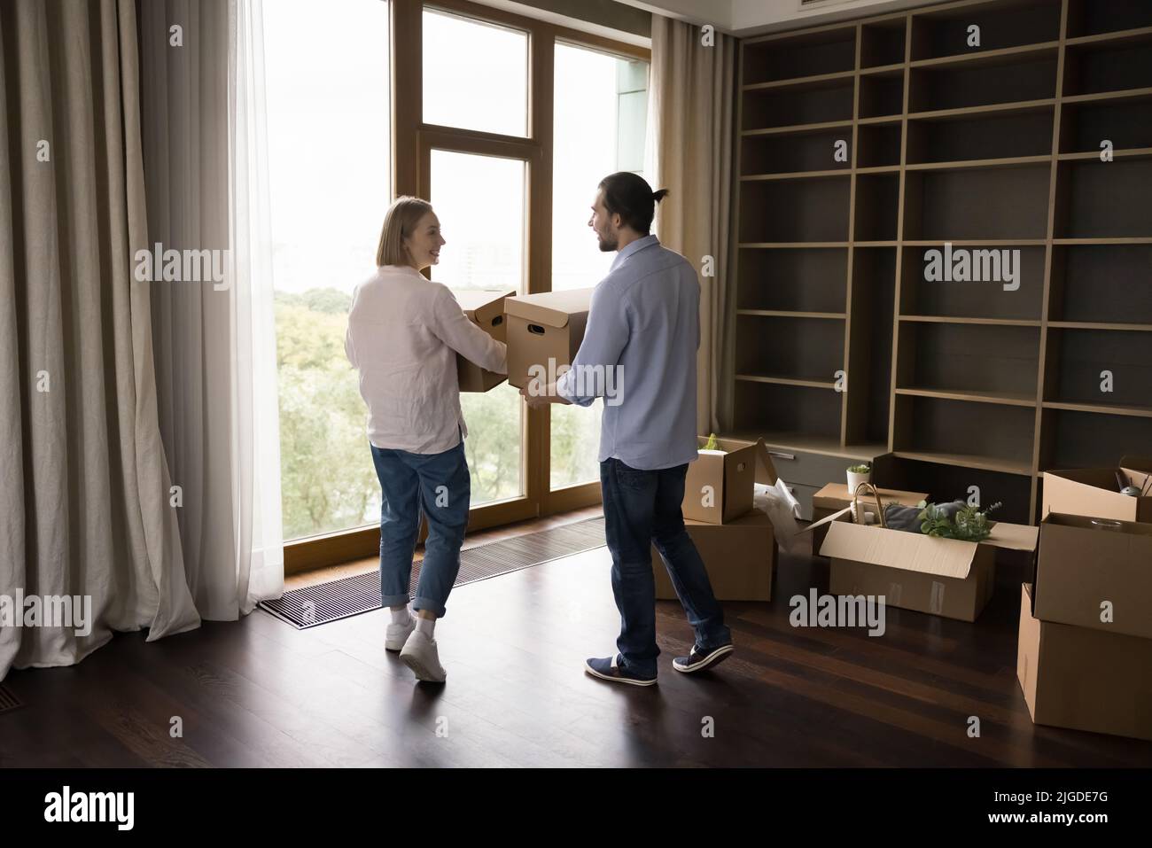 Felice coppia di affittuari, proprietari di casa che si trasferiscono in appartamento moderno Foto Stock