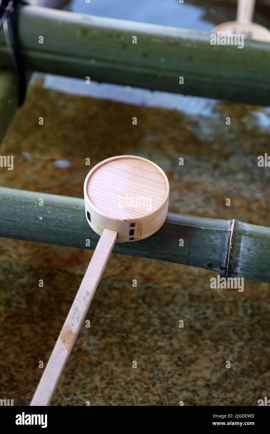 Un singolo mestolo di bambù usato per pulire le mani ai Templi giapponesi Foto Stock