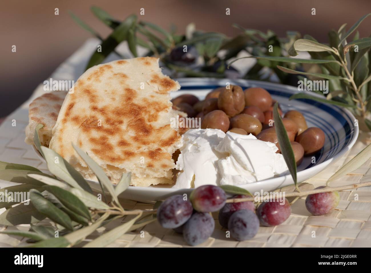 Colazione rustica mediterranea con pane bazlama, formaggio morbido e olive salate Foto Stock