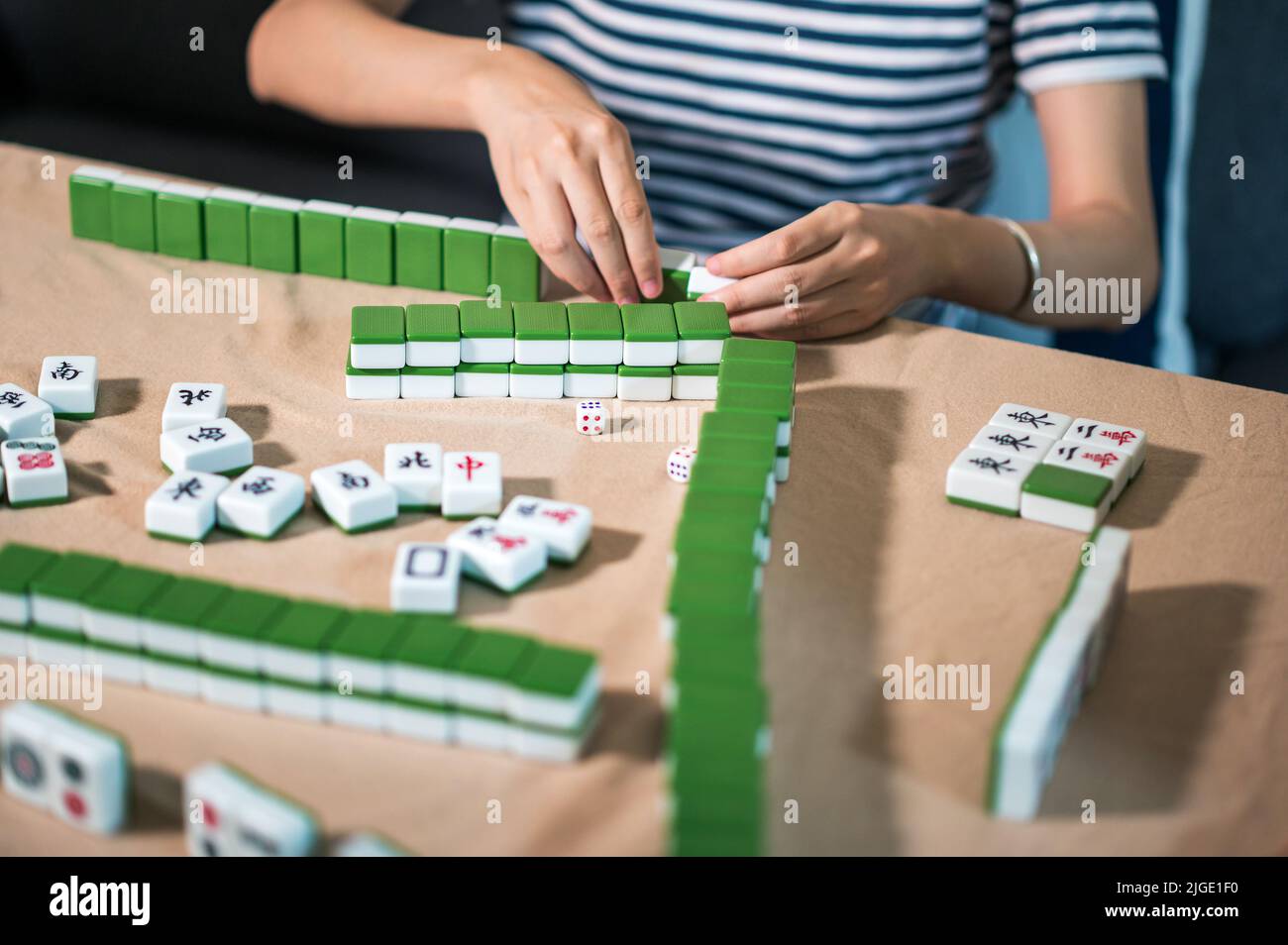 Amici femminili che giocano a mahjong tradizionale gioco da tavolo cinese a casa. Traduzione: Il testo Tile mostra caratteri cinesi per i numeri da 1 a 9 e si Foto Stock