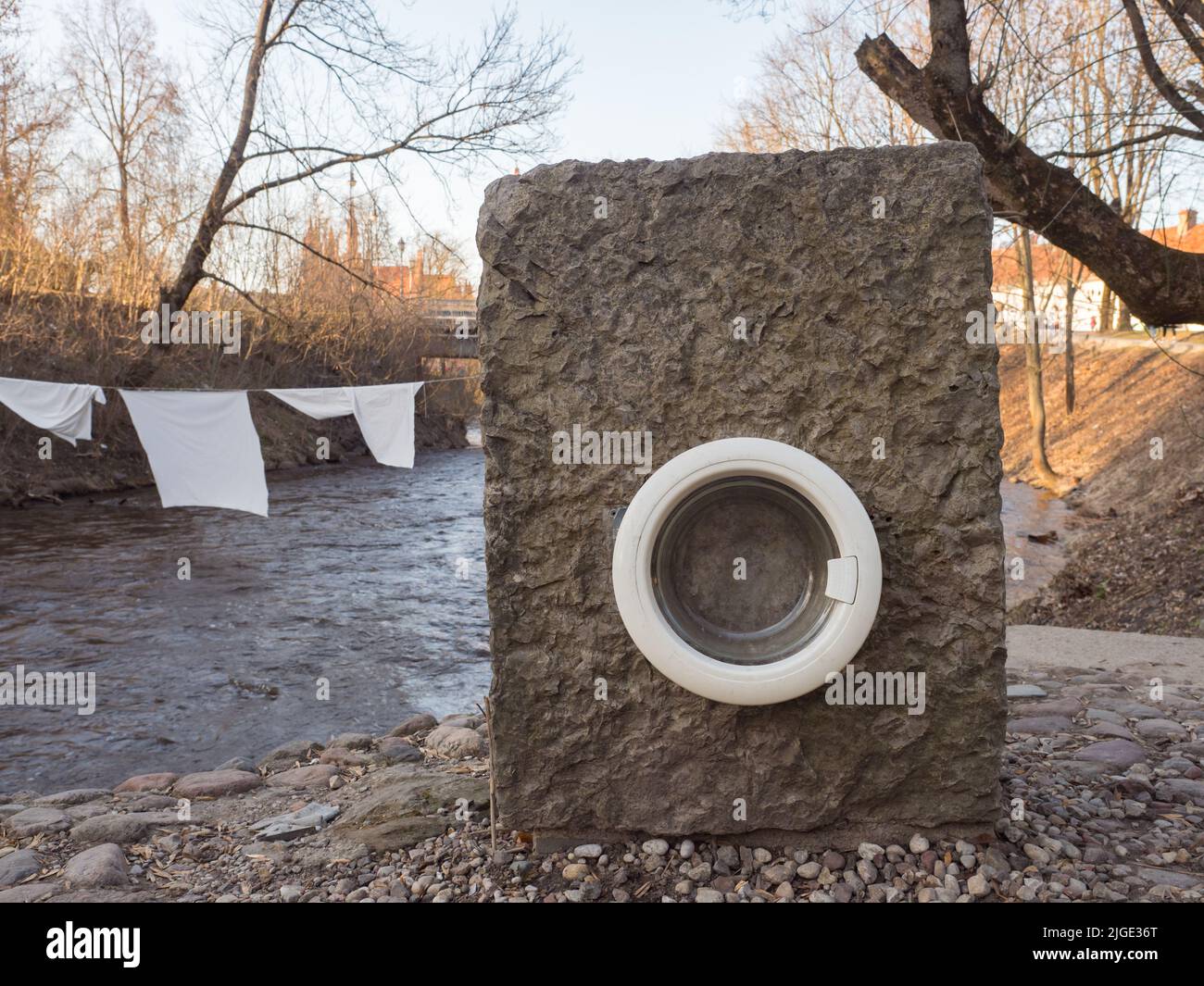 Užupis, Vilnius, Lituania - Aprile 2018: Una vecchia lavatrice sulle rive del fiume Wilenka nel distretto degli artisti di Uzupis a Vilnius. Užup Foto Stock
