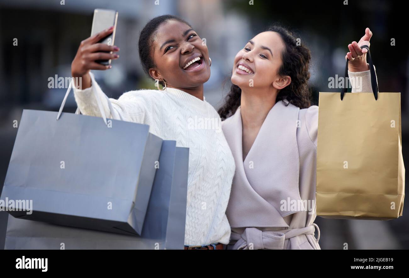 Siate i migliori amici per sempre. Due amici che prendono selfie mentre acquistano insieme. Foto Stock