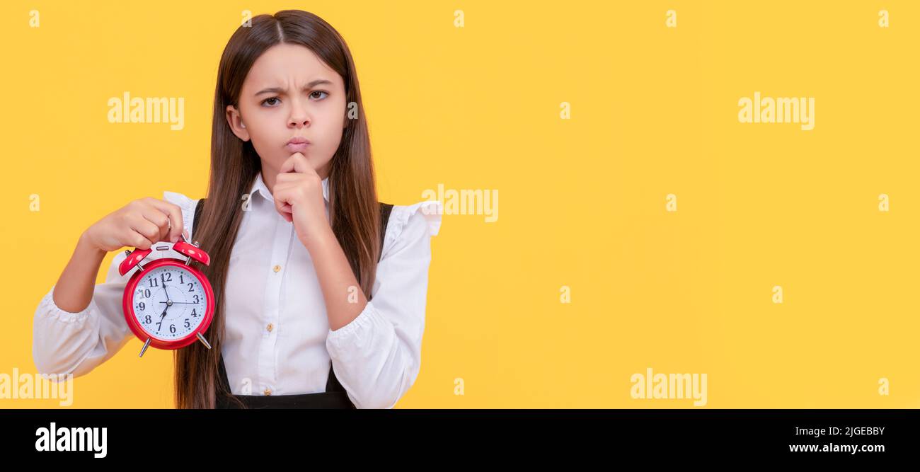 il bambino ponderante con la sveglia. il bambino della scuola in uniforme mostra il tempo. siete in ritardo. Bambino adolescente con sveglia, poster orizzontale. Intestazione banner Foto Stock