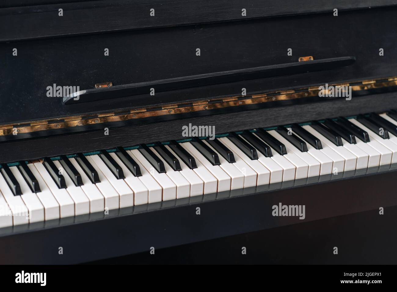 Il vecchio pianoforte nero. Primo piano dei tasti. Foto Stock