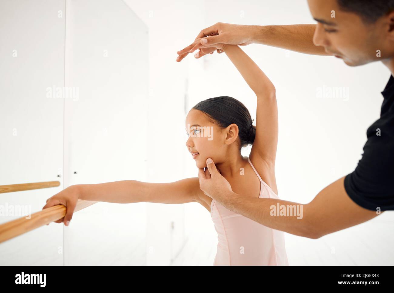 Balletto è di raffinatezza. Un insegnante di balletto che assiste uno studente con la sua posizione in uno studio di danza. Foto Stock