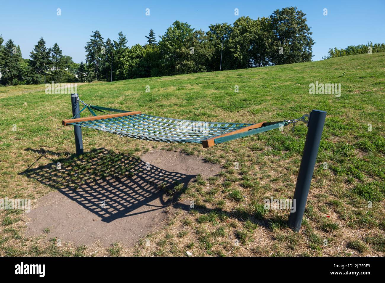 Grande amaca pubblica per due persone sul prato collinare, area ricreativa del parco urbano. Foto Stock