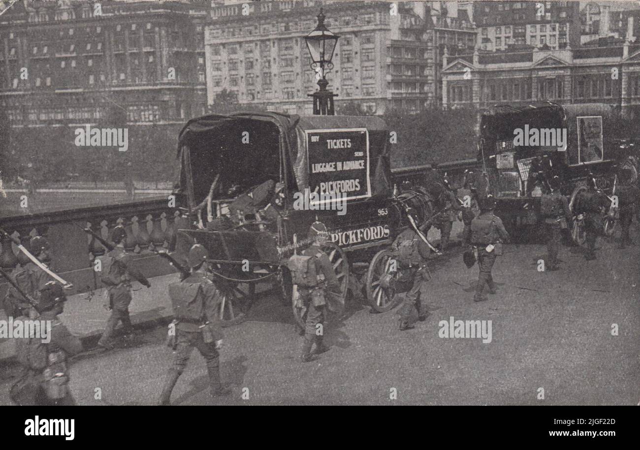 1911 sciopero ferroviario/dei trasporti a Londra. La fotografia mostra furgoni Pickfords trainati da cavalli scortati attraverso il Ponte di Waterloo da soldati che trasportano fucili con bayonets fissi Foto Stock