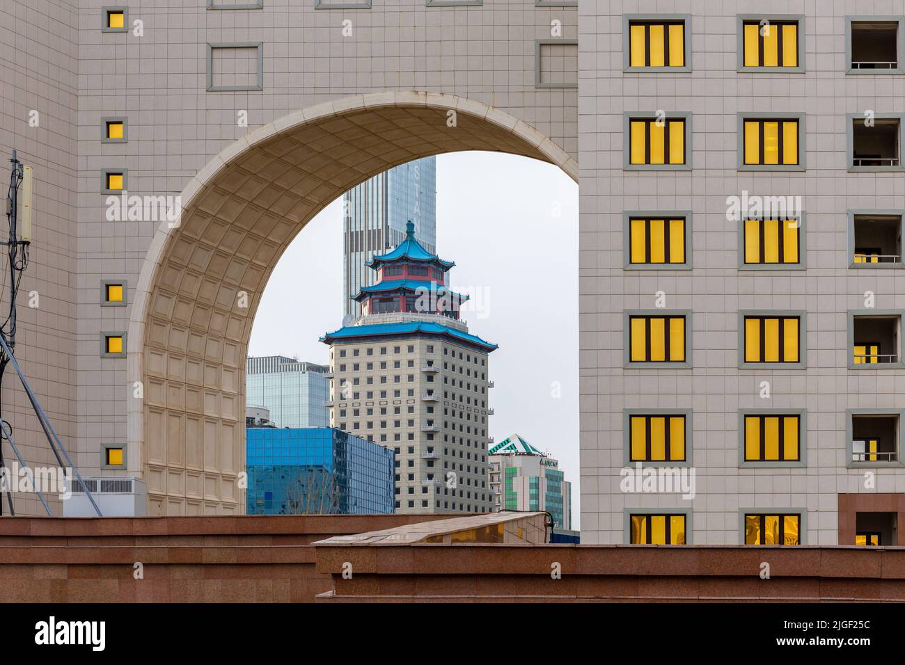 Nur Sultan (Astana), Kazakistan, 11.11.21. Beijing Palace Soluxe Hotel Astana edificio con tradizionale tetto blu cinese visto attraverso un arco in oro Foto Stock