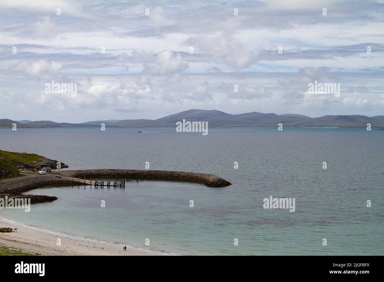 Breakwater, terminal dei traghetti di Eriskay a Ceann à Ghàraidh con barra sullo sfondo Foto Stock