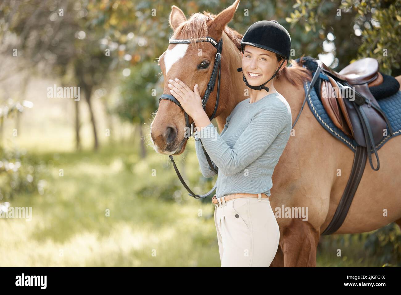 I cavalli cambiano la vita. Una giovane donna attraente in piedi con il suo cavallo in una foresta. Foto Stock