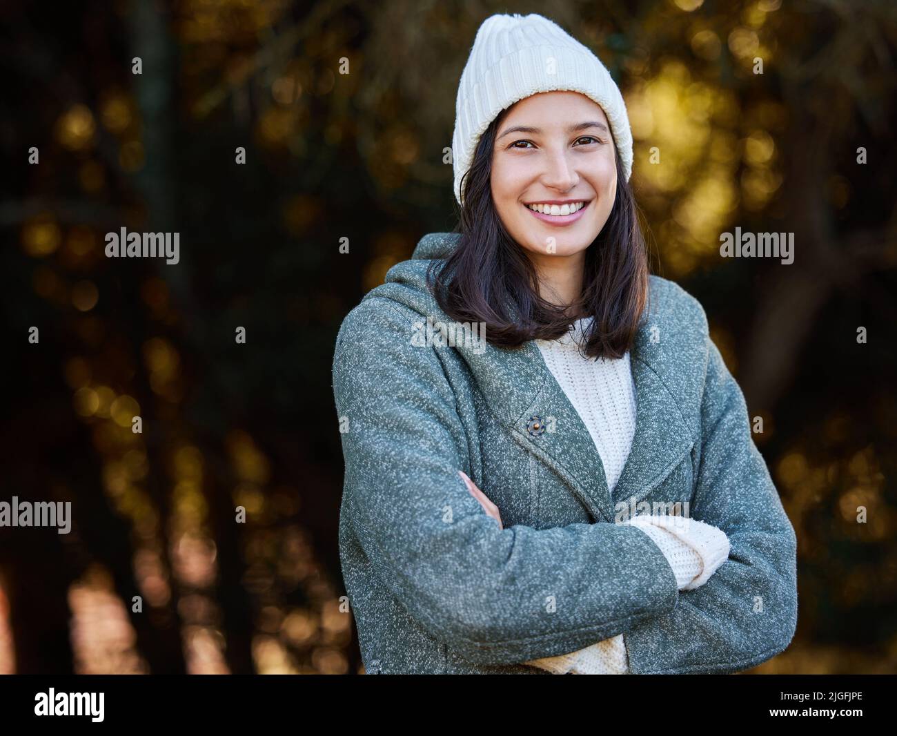 L'inverno è in arrivo: Una giovane donna attraente che si alza da sola all'esterno con le braccia ripiegate. Foto Stock