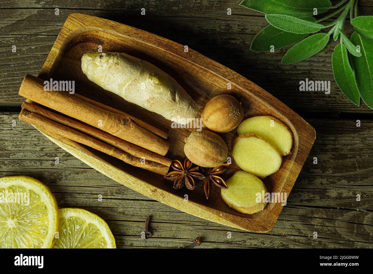 Ingredienti tè zenzero limone cannella chiodo zafferano salvia rustico primo piano Foto Stock