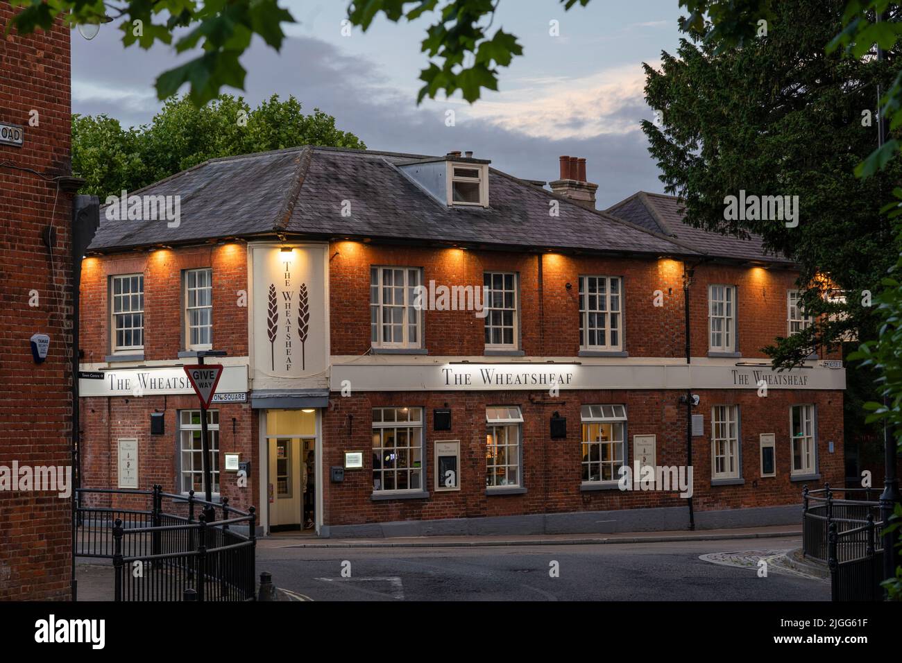 Il Wheatsheaf pub illuminato al crepuscolo su Winton Square, un tradizionale pub del centro città a Basingstoke, Hampshire, Inghilterra Foto Stock