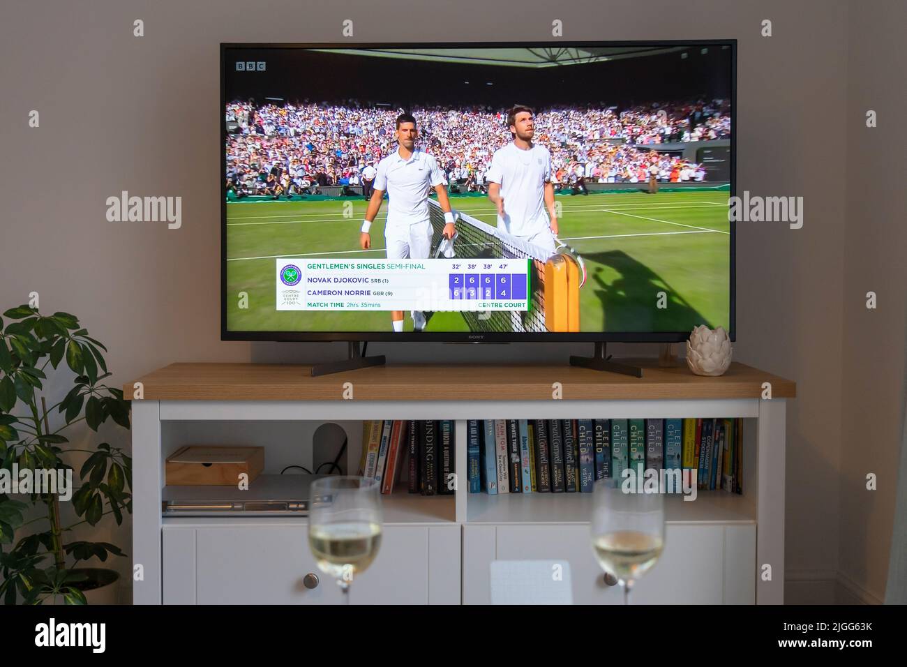 Cameron Norrie e Novak Djokovic in rete e la fine della finale di Wimbledon 2022 uomini di tennis singolo il 8th luglio 2022 su una tv in una sala. REGNO UNITO Foto Stock
