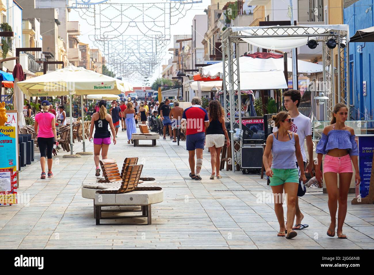 I turisti camminano lungo la strada principale in cui ci sono numerosi bar, negozi e altre attività principali. LAMPEDUSA, ITALIA - AGOSTO, 2019 Foto Stock