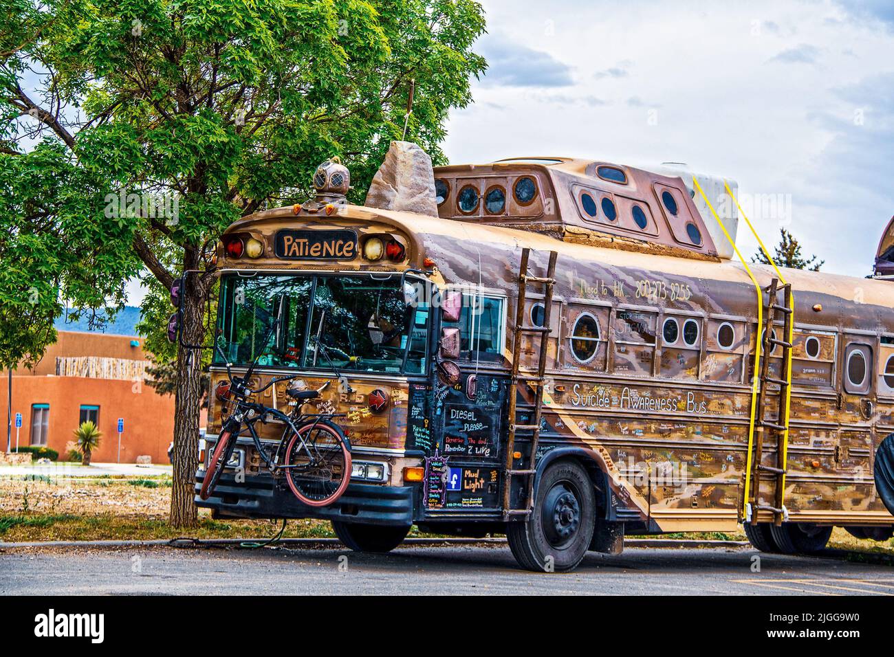 2021 05 21 Taos NM USA Steampunk convertito art bus per la consapevolezza di viaggio e suicidio con firme in tutto e la bicicletta fissata alla parte anteriore Foto Stock