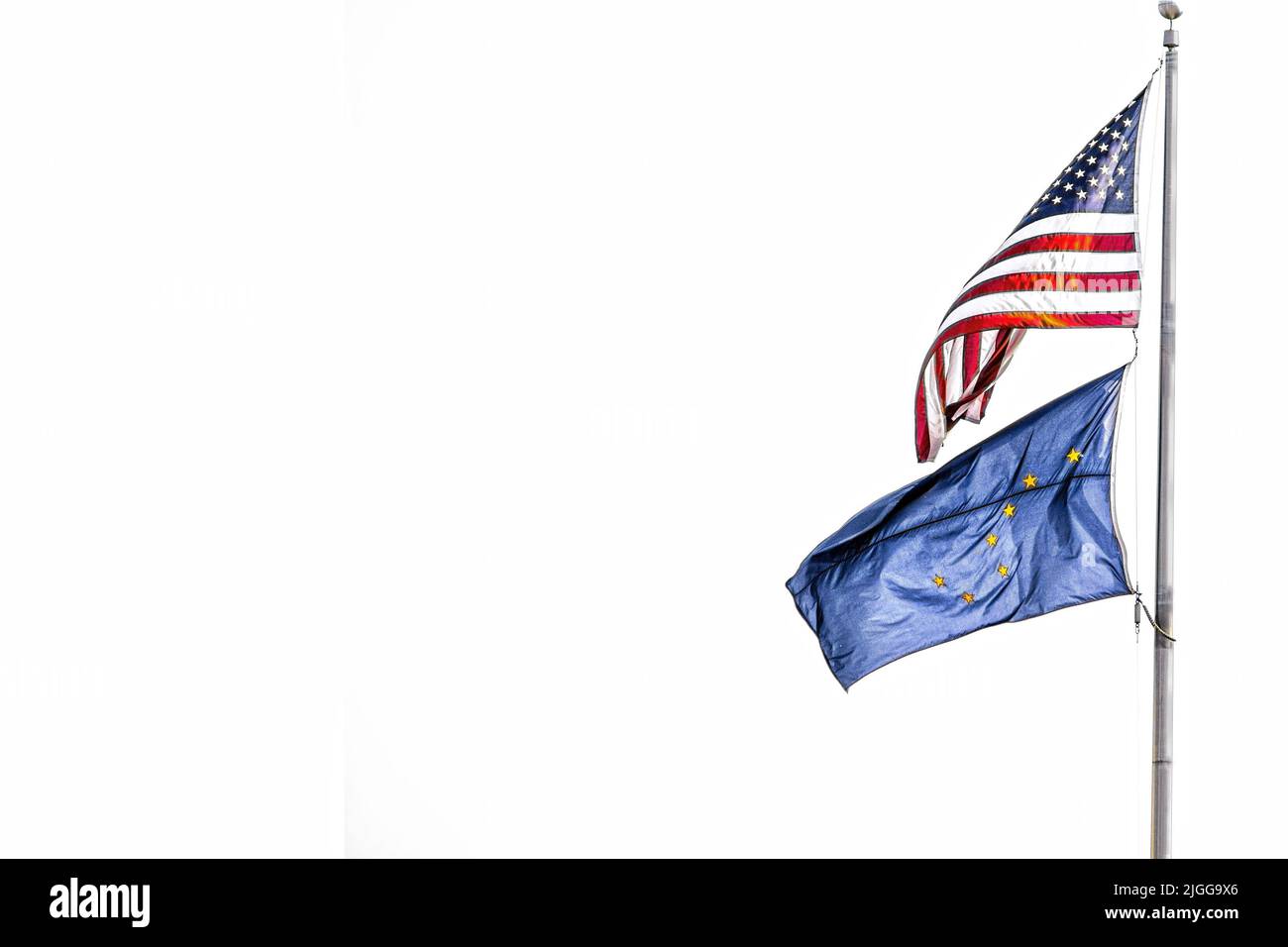 Bandiere americane e dell'Alaska che volano dal palo su un lato dell'immagine - isolate su bianco - stanza per la copia Foto Stock