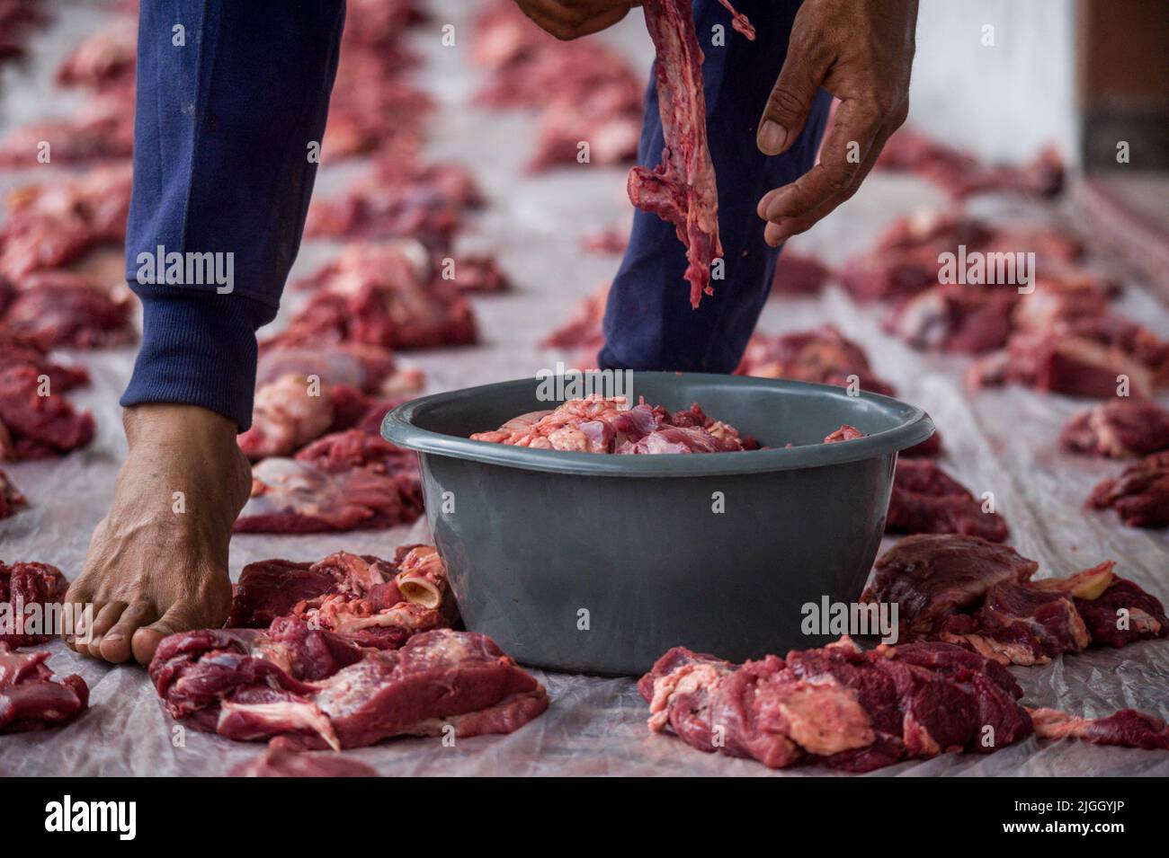 Musulmano visto distribuire la carne Qurban durante il mentre Eid al-Adha festeggiamenti alla moschea di Tiga Serangkai con lo sfondo attività del vulcano Sinabung nel villaggio di Kuta Tengah, subdistretto di Simpang Empat, distretto di Karo, provincia di Sumata Nord, Indonesia il 10 luglio 2022. L'Eid al Adha è il sacro slancio dei musulmani in tutto il mondo, dalle rivelazioni di Allah o di Dio al profeta Ibrahim e al profeta Ismail, che sono diventati il centro di valore dell'umanità per mantenere la fede in Dio, Questo è legato al modo in cui le persone devono affrontare le serie di prove della vita fino all'eruzione vulcanica Sinabung, e anche il COVID-19 pa Foto Stock