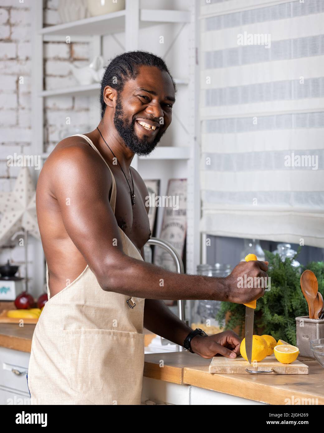 Uomo in un grembiule divertenti foto con arance in cucina Foto stock - Alamy