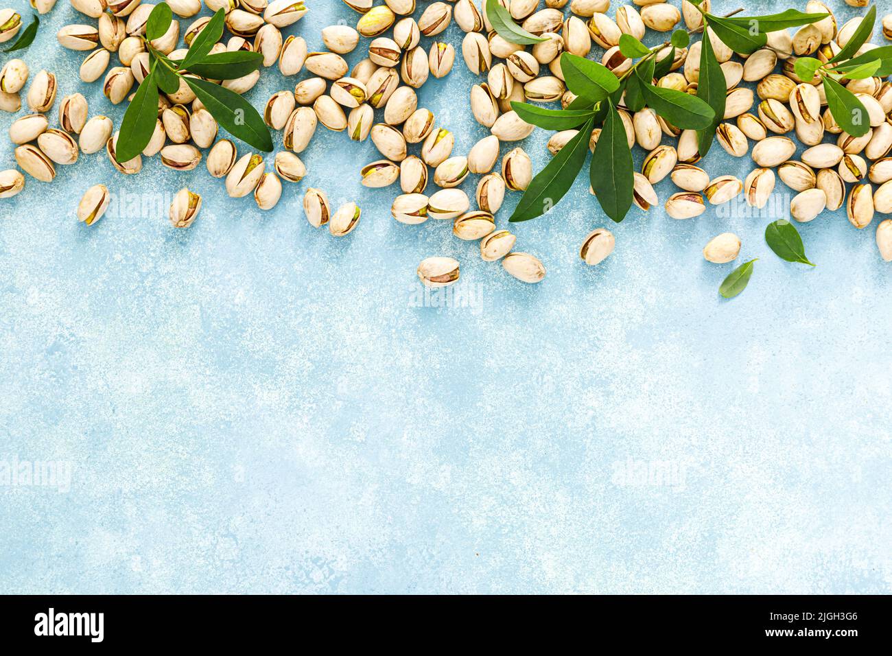 Pistacchi. Pistacchio con foglie verdi. Cibo biologico vegetariano sano e naturale. Vista dall'alto, spazio di copia Foto Stock