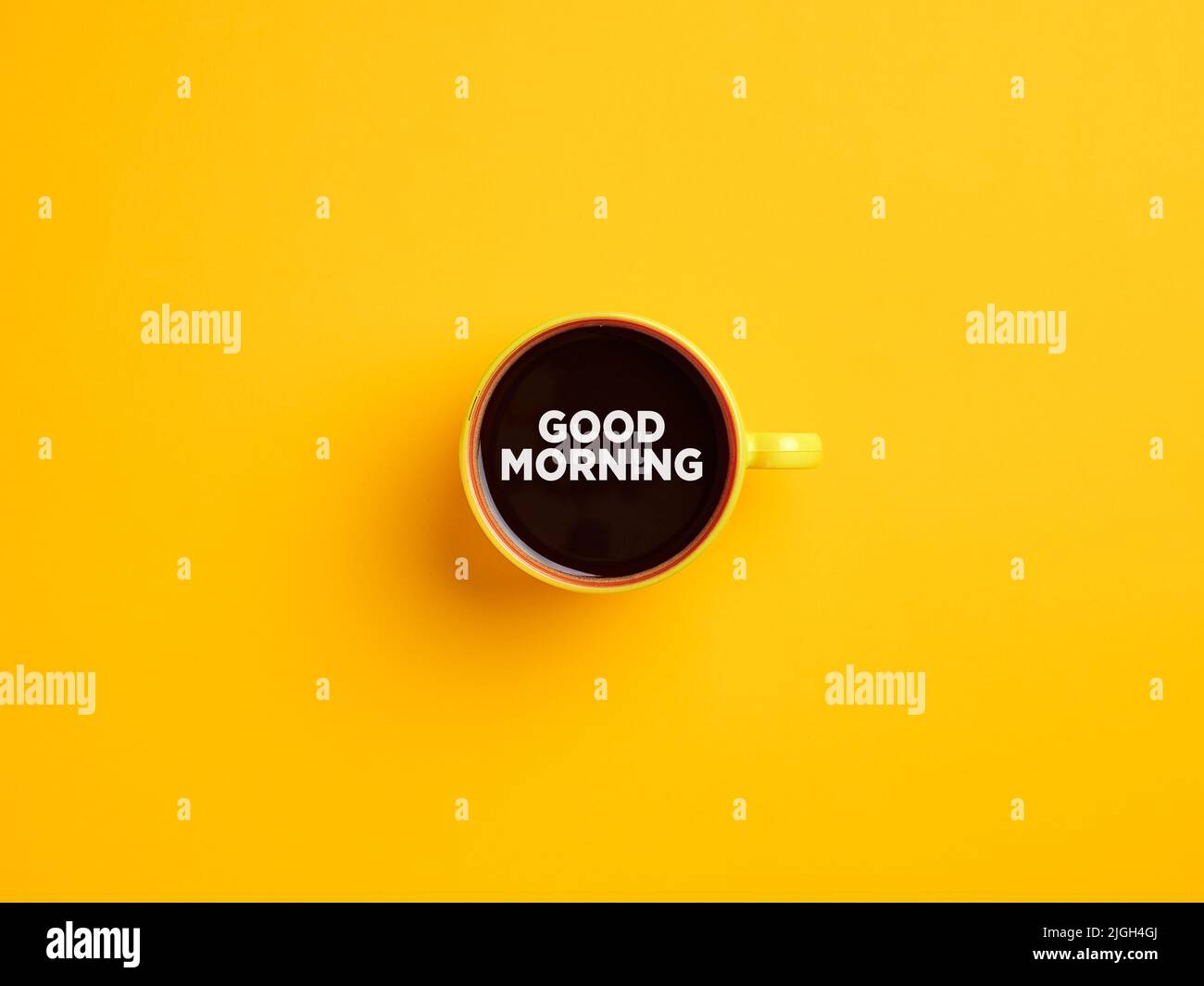 Tazza di caffè gialla con il messaggio Buongiorno su sfondo giallo. Caffè del mattino. Foto Stock