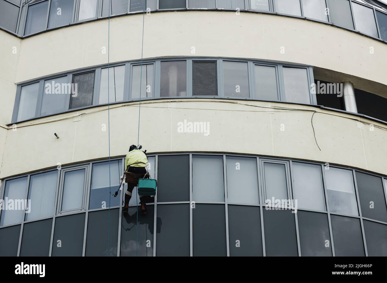 Lavaparabrezza pulizia facciata edificio. Lavori in altezza. Alpinismo industriale. Lavaparabrezza alto Foto Stock